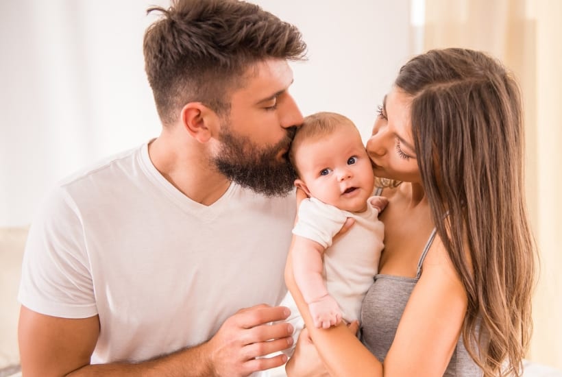 picture of mom and dad holding baby learning about newborn hacks